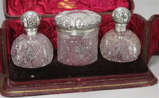 A cased late Victorian repousse silver mounted cut glass three piece toilet set by Mappin & Webb, London, 1899,